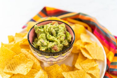 Klasik guacamole sosu küçük bir kasede mısır tortilla cipsi ile.