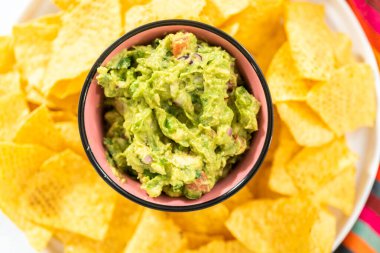 Klasik guacamole sosu küçük bir kasede mısır tortilla cipsi ile.