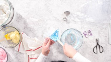 Düz yatıyordu. Adım adım. Tek boynuzlu at meringue kurabiyesi pişirmek için metal uçlu boru torbalarına krema karıştırılıyor..