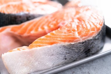 Parşömen kağıdıyla pişirme tepsisinde çiftlik somonu bifteği..