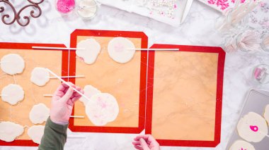 Düz yatıyordu. Büyük ev yapımı lolipopları silikon minderden soyuyorlar..