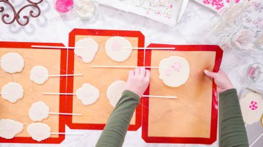 Düz yatıyordu. Büyük ev yapımı lolipopları silikon minderden soyuyorlar..