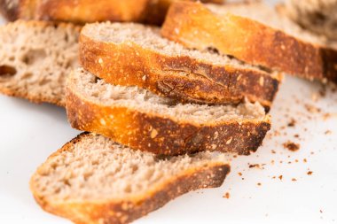 Beyaz bir kesme tahtasının üzerinde taze pişmiş ekşi ekmek dilimliyorum..