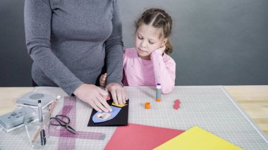 İnşaat kağıdından el yapımı Babalar Günü kartı yapan küçük bir kız..