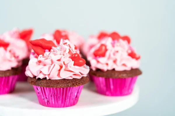 红色天鹅绒纸杯蛋糕 粉红意大利奶油糖霜 心形装饰 吻状红巧克力 — 图库照片