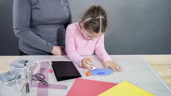 İnşaat kağıdından el yapımı Babalar Günü kartı yapan küçük bir kız..