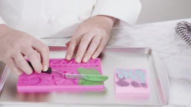 Vanilyalı kekleri süslemek için silikon kalıplı çikolata denizkızı kuyruğu yapıyorum..