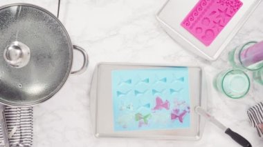 Vanilyalı kekleri süslemek için silikon kalıplı çikolata denizkızı kuyruğu yapıyorum..