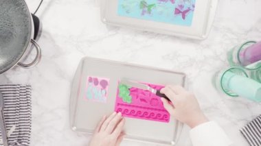 Silikon çikolata kalıplarını denizkızı kuyruğu ve deniz kabuğu şeklinde eritilmiş çikolatayla dolduruyorlar..