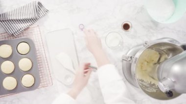 Üzerinde mavi tereyağlı krema süslemesi ve çikolata denizkızı kuyruğu ile süslenmiş gurme deniz kızı kekleri yapıyorlar..