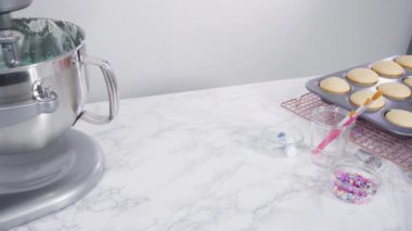 Üzerinde mavi tereyağlı krema süslemesi ve çikolata denizkızı kuyruğu ile süslenmiş gurme deniz kızı kekleri yapıyorlar..