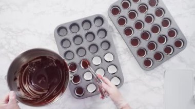 İtalyan tereyağı kremalı çikolatalı mini kekler. Parlak çikolatalı kar taneleriyle süslenmiş..