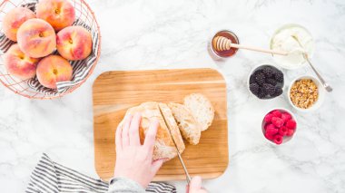 Düz yatıyordu. Adım adım. Bir somun ciabatta ekmeğini tahta kesme tahtasında ekmek bıçağıyla dilimlemek..