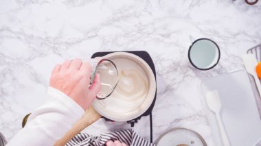 Düz yatıyordu. Adım adım. Küçük elektrikli ocağın üzerinde küçük bir tencerede karamelize şeker.