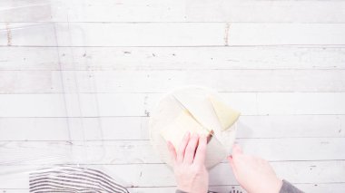 Düz yatıyordu. Adım adım. Mutfak bıçağıyla beyaz bir kesme tahtasının üzerinde gurme peyniri dilimlemek..