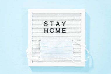 Mesaj panosunda mavi bir tıbbi maskeyle ev tabelası var..