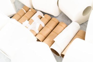 Gri arka planda yeni ve boş tuvalet kağıdı ruloları.