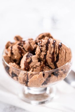 Ev yapımı çikolata parçalı dondurmayı cam bir kasede çikolatayla servis ediyorum..