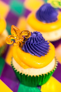 Mardi Gras vanilyalı kekler folyo kaplarda ve İtalyan tereyağlı kremayla süslenmiş..