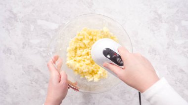 Düz yatıyordu. Adım adım. Kırmızı kadife kek hazırlamak için karıştırma kabındaki malzemeleri karıştırıyorum..