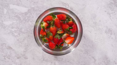 Düz yatıyordu. Adım adım. Suyla dolu bir kasede organik çilek yıkamak..