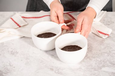 Beyaz bardaklarda çikolatalı kek hamuru pişmeye hazır..