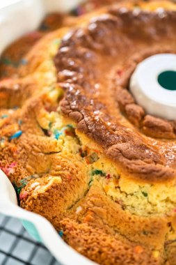 Manzarayı kapat. Taze pişmiş funfettti kekini tel askıda serinletiyor..