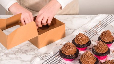 Adım adım. Çikolatalı kapkekleri çikolatalı ganache ile paketleyip kek kutusuna koymak..