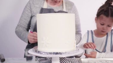 Adım adım. Yuvarlak funfetti pastasını pembe ve beyaz fondant kar taneleriyle süslüyorum..