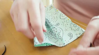 Koronavirüs salgını için dikiş makinesiyle pamuk yüz maskesi dikiyorum..