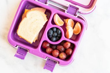 Sağlıklı okul öğle yemeği küçük bir kız için bir Bento kutusunda paketlenmiş.