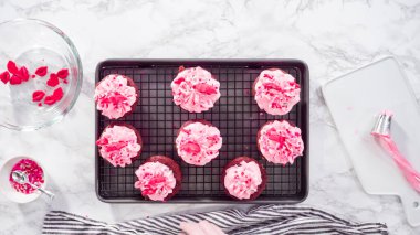 Düz yatıyordu. Adım adım. Çikolata kırmızısı kalpler ve öpücüklerle süslü kırmızı kadife kekler..