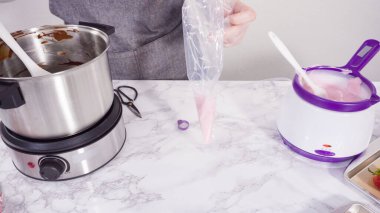 Adım adım. Çikolata parçacıkları eriyen kaplarda eriyor..