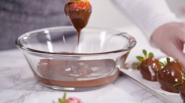 Adım adım. Erimiş çikolataya organik çilek batırmak..