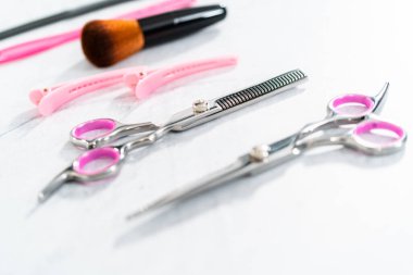 Gri arka planda pembe makasla yeni berber seti.