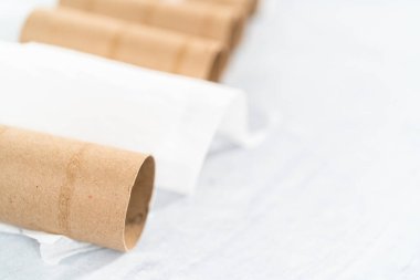 Gri arkaplanda boş tuvalet kağıdı ruloları kullanılıyor.