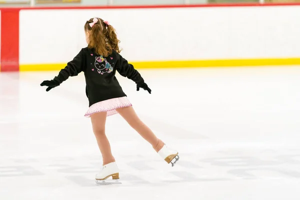 小さな女の子練習フィギュアスケート上の屋内アイススケートリンク — ストック写真