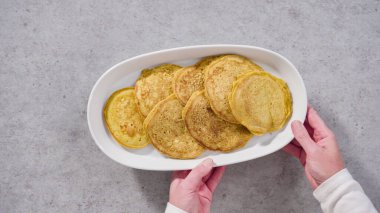 Adım adım. Düz yatıyordu. Beyaz servis tabağında taze yapılmış balkabaklı gözleme..