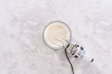 Düz yatıyordu. Krem peynirli krema hazırlamak için karıştırma kabındaki malzemeleri karıştırıyorum..