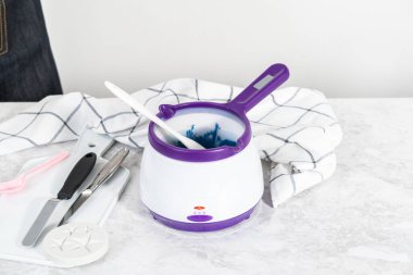 Çikolata parçacıkları eriyor elektrikli şeker tenceresinde.