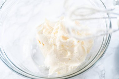 Marketten alınmış vanilyalı şekerlemeyi cam bir kaseyle karıştırıyorum..