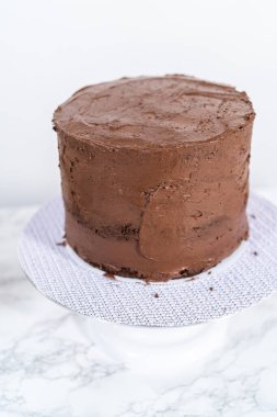 Çikolatalı pastayı çikolata kremalı kremayla kaplamak..