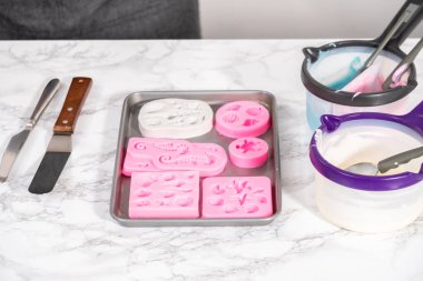 Silikon çikolata kalıplarını denizkızı kuyruğu ve deniz kabuğu şeklinde eritilmiş çikolatayla dolduruyorlar..