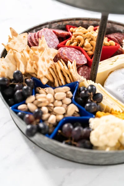 チーズ クラッカー サラミ 新鮮な果物でいっぱいの2層の金属製のスタンドに7月4日のシャルキュトリボード — ストック写真