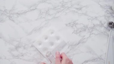 Adım adım. Mermer tezgahın üzerindeki beyaz fondanla kar tanelerini keserek..