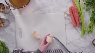 Çorba için organik malzemeleri beyaz fasulyeli beyaz kesim tahtasıyla hazırlamak ve kesmek..