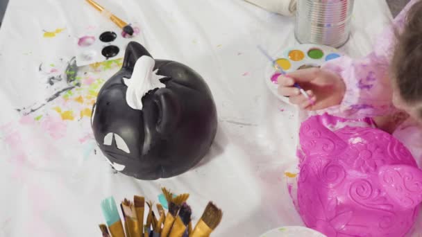 小女孩用丙烯酸粉刷万圣节南瓜 — 图库视频影像