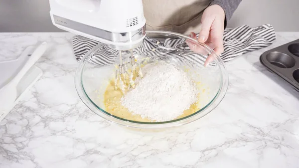 Step by step. Mixing ingredients in a mixing bowl to bake cranberry muffins.