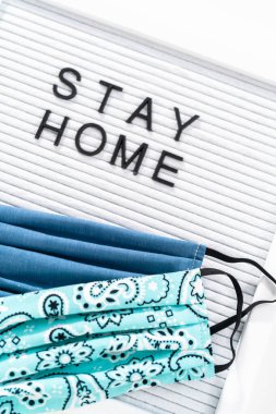 İleti panosunda ev yapımı yüz maskesi ile Ev Kal tabelası.