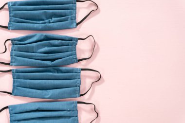 Pembe arka planda Coronavirus salgını için ev yapımı yüz maskeleri..